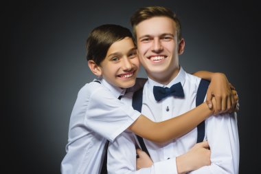 younger boy hugging his older brother. happy boys