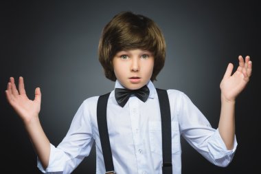 Gri arka plan karşı dururken hayret ifadesi ile yakışıklı çocuk portresi closeup