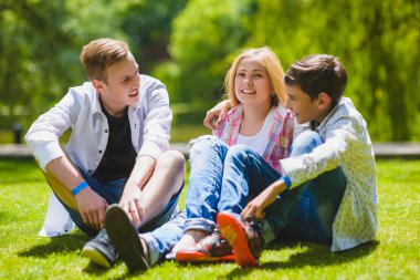 Gülümseyen çocuklar çim eğleniyor. Çocuklar açık havada yaz aylarında oynuyor. Gençler açık iletişim