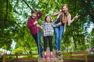 Gülümseyen çocuklar Bahçesi eğleniyor. Çocuklar açık havada yaz aylarında oynuyor. Gençler dışında bir salıncak üzerinde sürme