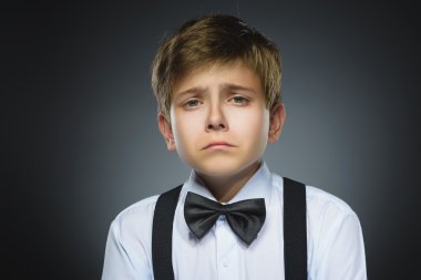 Gri arka planda izole edilmiş hücum ağlayan çocuğun portresi. Negatif insan duyguları, yüz ifadesi. Closeup