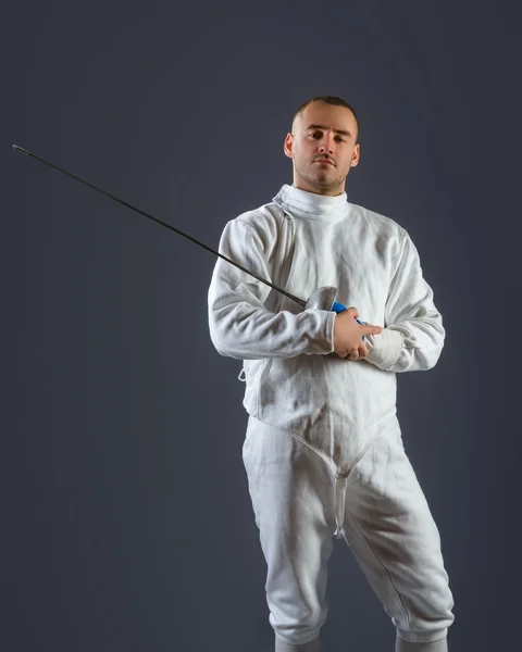 Esgrima atleta posando con una espada o epee sobre fondo gris — Foto de Stock