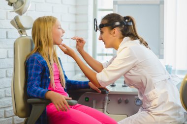 KBB doktoru ya da bir çocuğun boğazını inceleyerek Otolaryngologist
