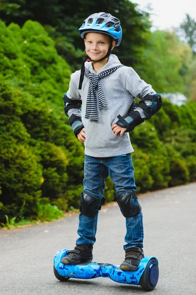 Niño feliz montando en hoverboard o giroscooter al aire libre — Foto de Stock