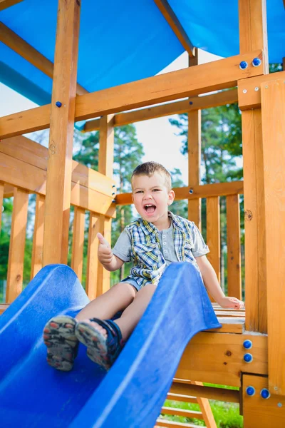 Χαμογελαστό παιδί που διασκεδάζουν στην παιδική χαρά. Παιδιά που παίζουν σε εξωτερικούς χώρους — Φωτογραφία Αρχείου