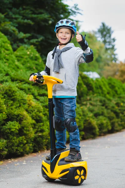Niño feliz de pie en el hoverboard o giroscooter al aire libre — Foto de Stock