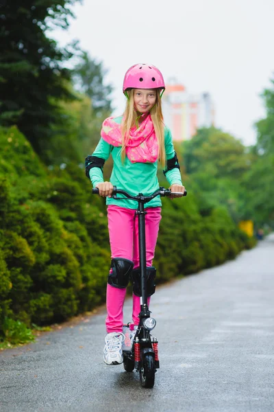 Chica feliz montando en scooter eléctrico al aire libre — Foto de Stock