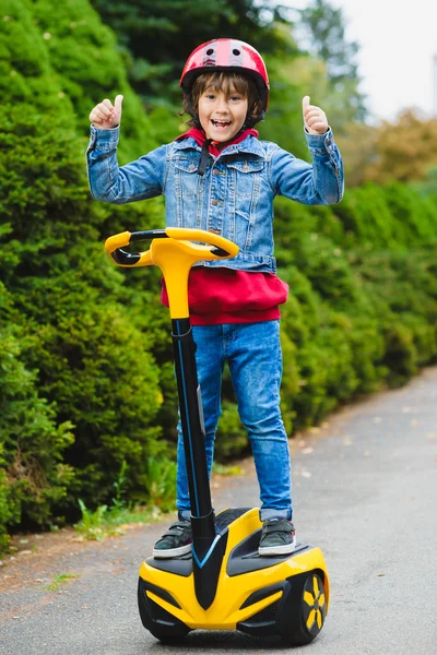 Niño feliz montando en hoverboard o giroscooter al aire libre — Foto de Stock