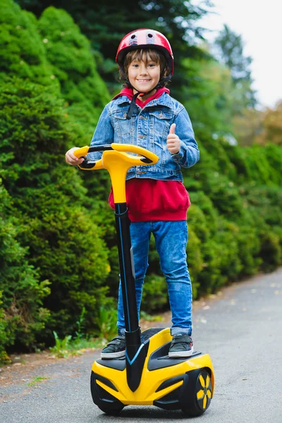 Niño feliz montando en hoverboard o giroscooter al aire libre — Foto de Stock