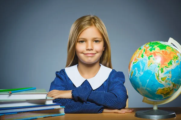 Concept van de school. meisje zit aan de balie in de klas Geografie — Stockfoto