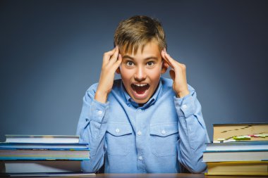 okul kavramı. şüpheli veya kızgın çocuk masa başında oturan