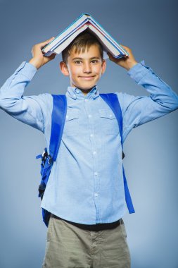 okul kavramı. kitap kafasında sırt çantası ile portre başarılı mutlu çocuk