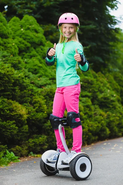 Chica feliz de pie en el hoverboard o giroscooter al aire libre — Foto de Stock