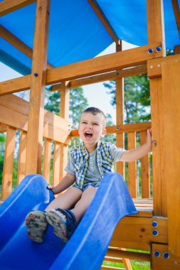Gülümseyen çocuk parkında eğleniyor. Açık havada oynayan çocuk
