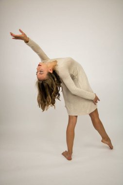 Dans eden güzel bir kızın koreografisi. Beyaz arka plan..