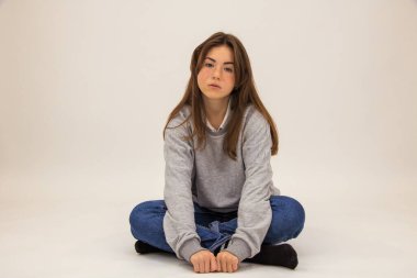 Güzel üfleyici beyaz bir öğrencinin zemininde oturur meditasyonun neşesi sakin mutluluk gülümsemesi