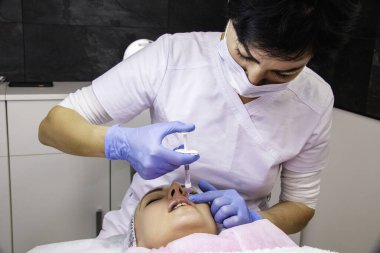 Kozmetik, dudak büyütme, güzellik salonunda güzellik aşıları, yakın çekim.