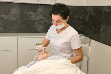 Hastanın yüzünü estetik ameliyata hazırlamak, anestezi kremi.