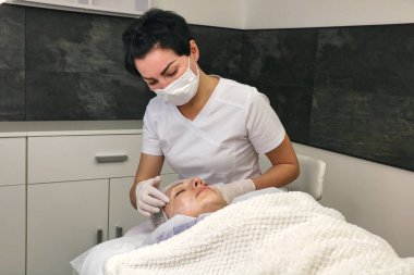 Hastanın yüzünü estetik ameliyata hazırlamak, anestezi kremi.