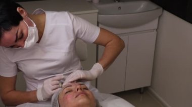 Biyolojik evrim, mezoterapi prosedürü, hiyalüronik asit enjeksiyonları, cilt gelişimi ve gençleştirme, yüz hatlarını düzeltme, güzellik uzmanı ve hasta, yakın çekim.