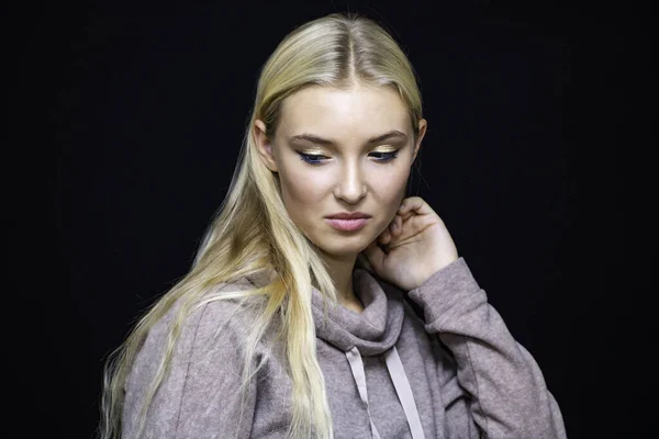 girl with a bad mood expresses emotions of dissatisfaction and disappointment, close-up on a black background.