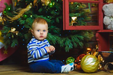 Noel ağacı yakınındaki kutlamanın bir yaşında çocuk