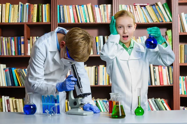 Lindo chico y chica haciendo investigación bioquímica en clase de química —  Fotos de Stock