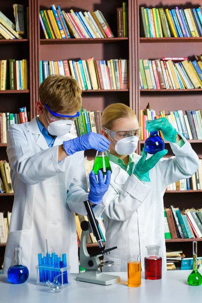 Fajny chłopak i dziewczyna robi badania biochemii w klasie chemii — Zdjęcie stockowe