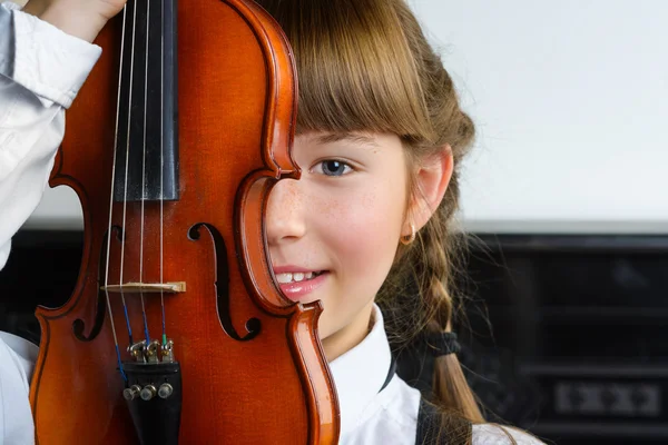 Carina bambina che tiene un violino al coperto — Foto Stock