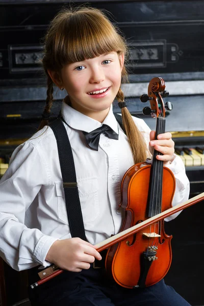 Carina bambina che tiene un violino al coperto — Foto Stock