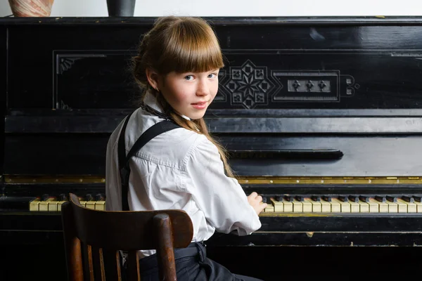 Jovem menina tocando piano interior — Fotografia de Stock