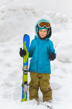 Mavi bir ceket ve Kayak açık kış gününde çocukta
