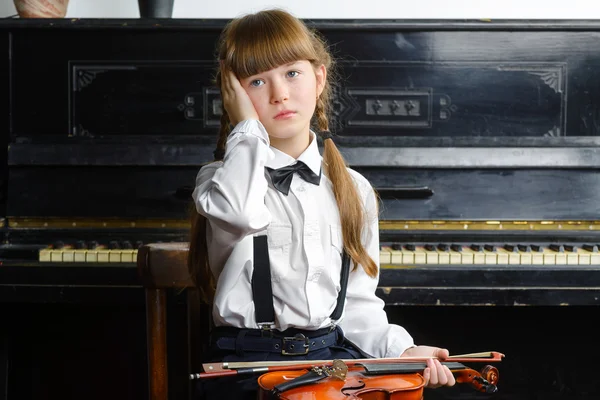 Sconvolto o angosciato ragazza stringendo la testa e tenendo un violino — Foto Stock