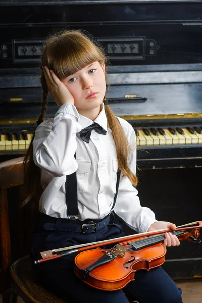 Sconvolto o angosciato ragazza stringendo la testa e tenendo un violino — Foto Stock