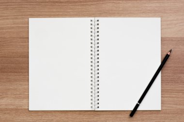 Boş yüzük spiral ciltleme defter bir kalem ahşap yüzeyde açıldı