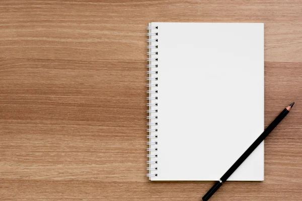 Boş yüzük spiral ciltleme defter bir kalem ahşap yüzeyde açıldı