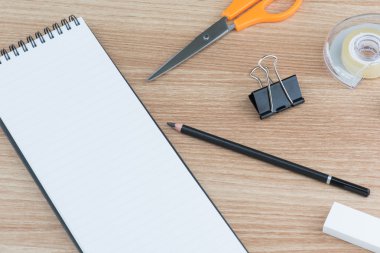 Ahşap yüzey üzerinde sabit boş yüzük spiral ciltleme çizgili not defteri açıldı