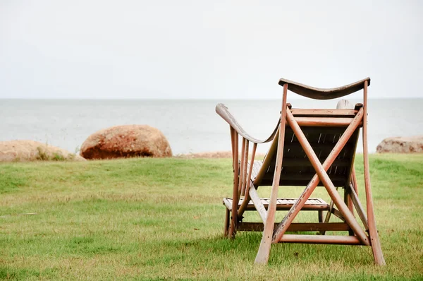 Egy fából készült szék, egy fehér homokos strand közelében szeretnének az óceán — Stock Fotó