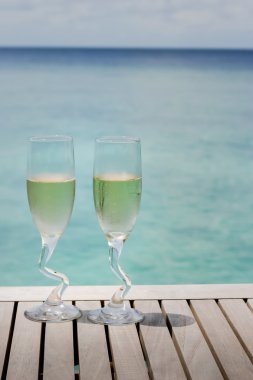 İki şampanya bardağı okyanus tarafından