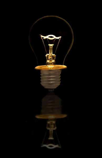 Incandescent light bulb on black background — Stock Photo, Image