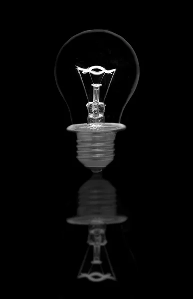 Incandescent light bulb on black background — Stock Photo, Image