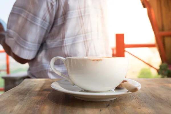Fechar uma xícara de café na mesa de madeira — Fotografia de Stock