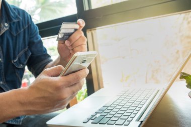 Online ödeme, online alışveriş için akıllı telefon tutarak adamın elleri