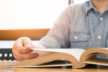 Ahşap masa ve okuma kitabı ile oturan yakın çekim kadınlar.