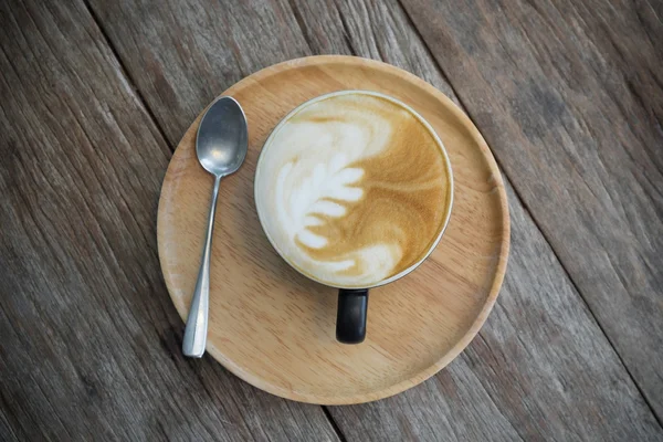Xícara de café com arte latte em uma mesa de madeira. Tábuas de madeira velhas. filtro retro vintage — Fotografia de Stock