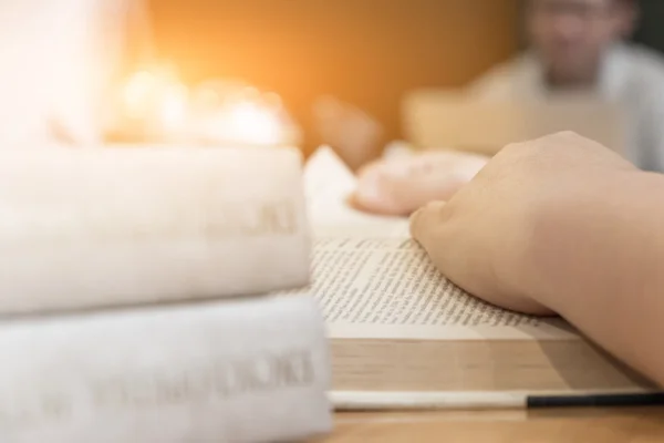 Close-up women sitting by wooden table and reading book. — Stock Photo, Image