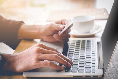 Online ödeme, kredi kartı tutan ve vintage ile online alışveriş için dizüstü bilgisayar kullanarak adamın elleri etkisi filtre.