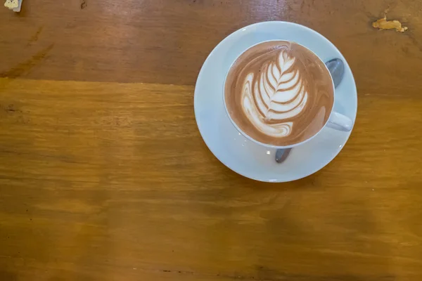 Tazza di caffelatte art su tavolo in legno vista dall'alto — Foto Stock