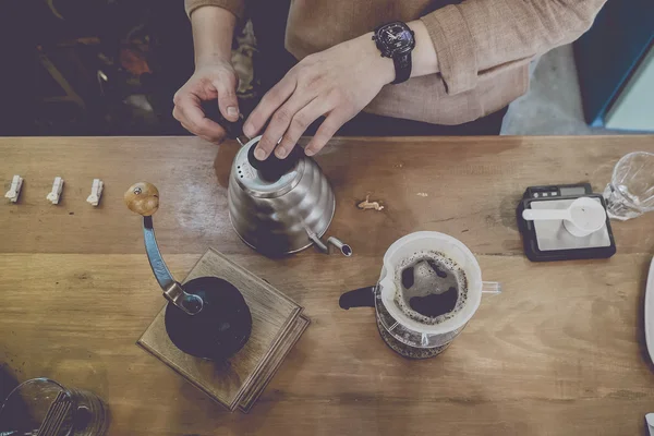 El damla kahve, Barista filtre ile kahve öğütme üzerine su döküyor. üst görünüm