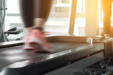 Bir spor salonunda egzersiz için bir koşu bandı kavram üzerinde çalışan kadın